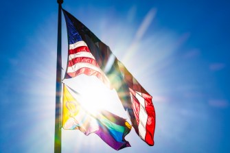 LGBTQ Pride旗在美国国旗下飞,两者后都带太阳